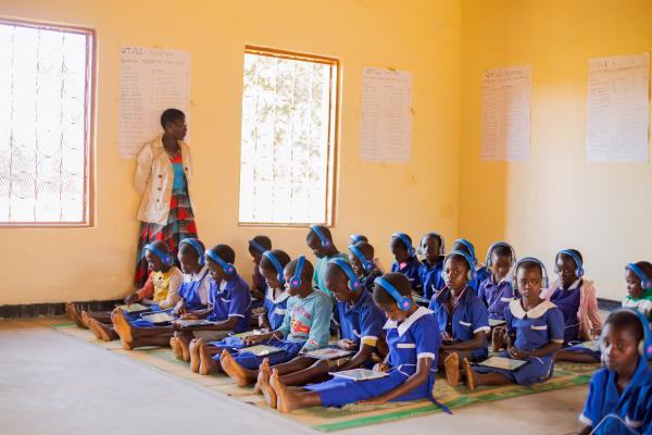 Children sit down on the mats in the learning centre