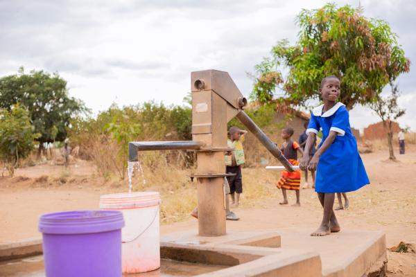 Alinafe collects water from the water pump in her village