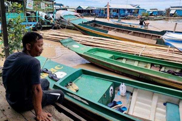 Man sat by boats