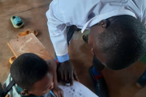 Teacher Olivier helps a student in his class