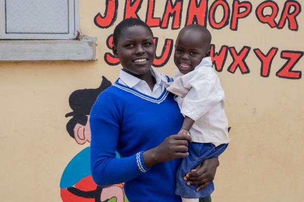 Student Emily stands outside her school with her son, Shedi