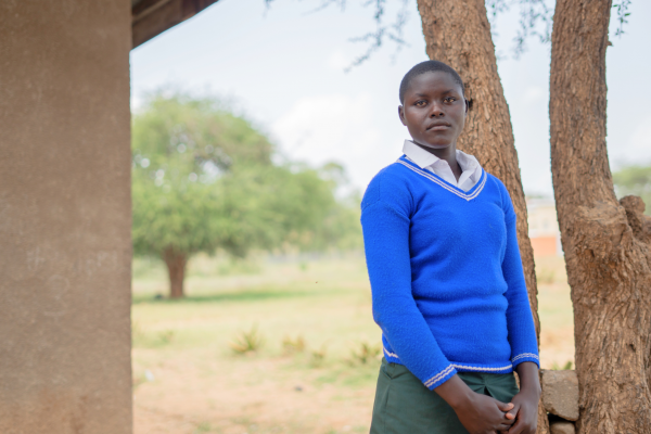 Emily stands in her school