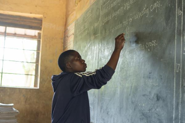 Juliet in her classroom writing on the board