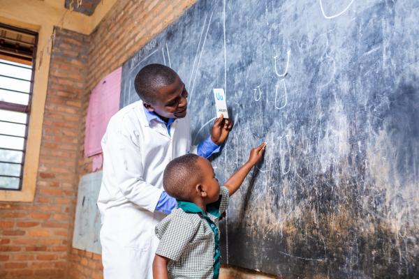 Shakila with teacher Olivier during a lesson activity on learning letters