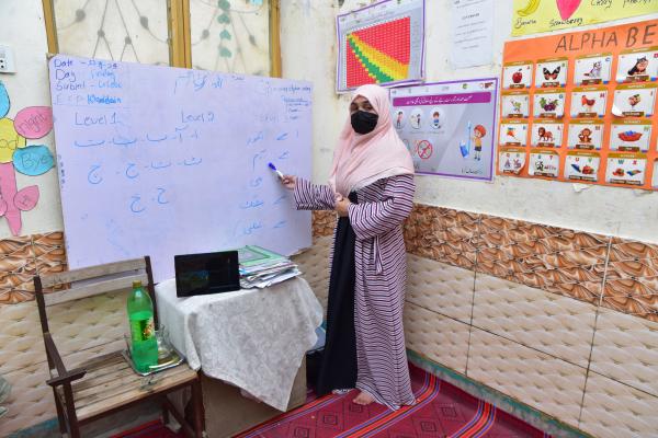 Khadija at the front of the classroom teaching a lesson