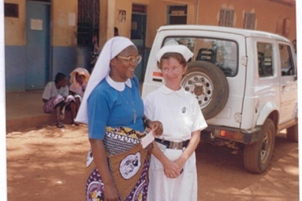 Erin with a fellow health worker outside a hospital in Tanzania.
