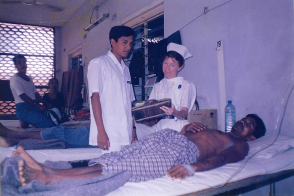 Erin with a patient and a fellow health worker on a hospital war in Bangladesh
