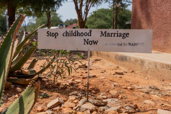 A sign in a playground that says: Stop childhood marriage now.