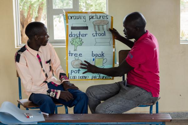 VSO volunteer Alfred (right) delivering some training to a teacher (left).