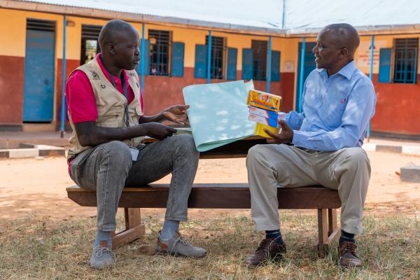 VSO volunteer Alfred and teacher Stanley looking through school materials.