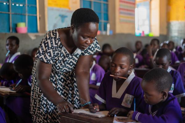 Teacher Barbra helping Nakiru with her school work in class.
