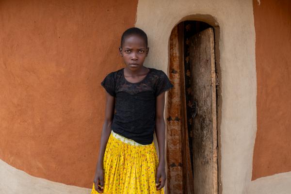 Student Nakiru standing outside her home.