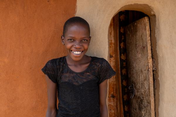 Nakiru smiling, outside her home.