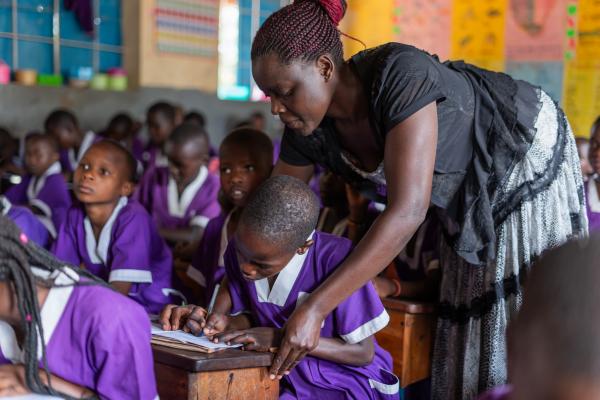 Teacher Yeko helping Nakiru with her school work in class.