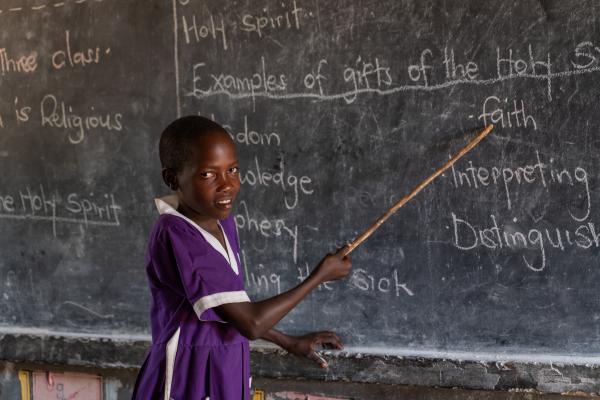 Student Nakiru, pointing at the blackboard with a cane.