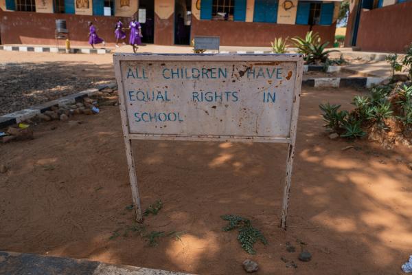 A sign that reads 'All children have equal rights in school' in the school playground.