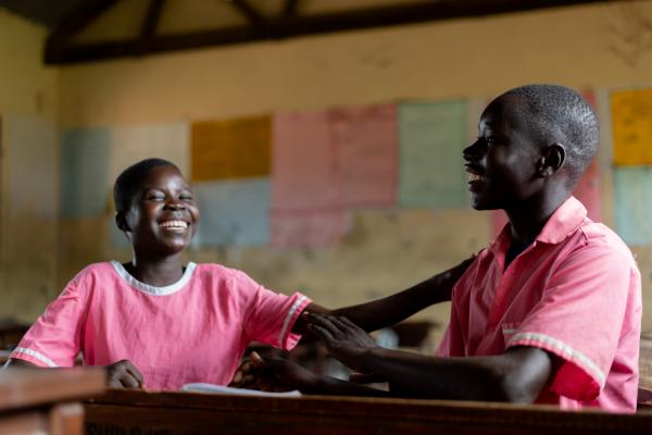 Students Nangiro and Patrick, laughing together in the classroom.