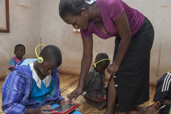 Teacher Stembile Naming'ona assists special needs pupil, Halima Ali, work on her tablet on VSO Malawi's Unlocking Talent project Teacher and pupils using tablet edutech technology in the classroom in Lilongwe Malawi | VSO