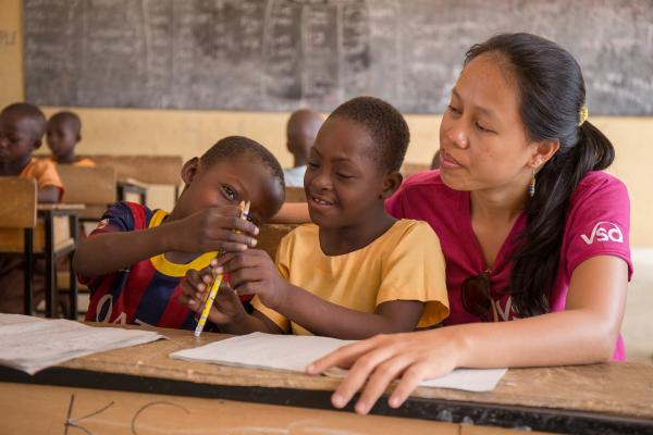 7-year-old Blessing Asokiyine (centre) with her 6-year-old classmate Klevin Atinga and VSO volunteer Mary Carnable, at Goriko kindergarten in Talensi District, Bolgatanga, Ghana.