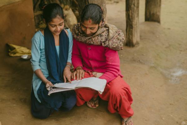 Pramila showing her work to her mother. Pramila, 13, is a ‘Little Sister’ on VSO’s Sisters for Sisters’ Education (S4S) project in Surkhet, Nepal.