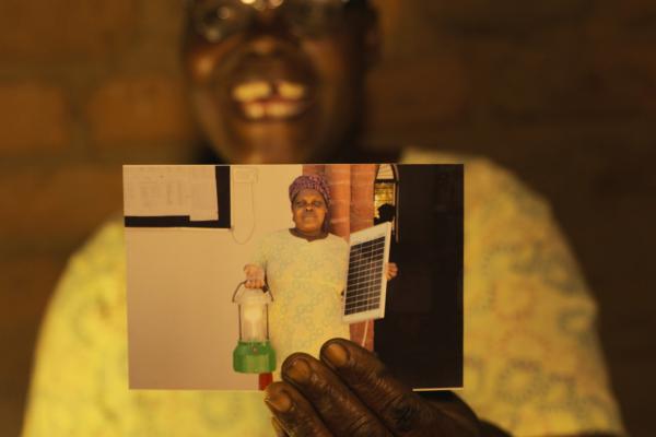 Solar Mama Dines holds up a photo from her graduation day Malawian woman holds up a photograph