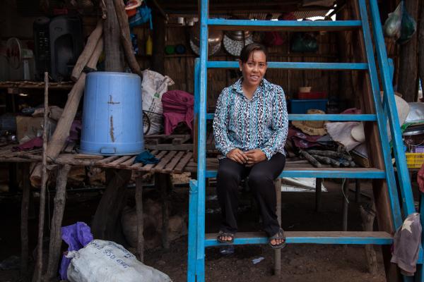 Chaun Lan, 42, has lived on the Tonlé Sap Lake all her life, which has been plagued by illegal fishing and the effects of climate change. Image of Chaun Lan, 42, sitting down in fishing hut.