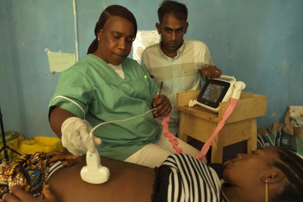Midwife Catherine Swaray scans 17-year-old Mariama Jalloh, assisted by VSO volunteer Dr Kiran Cheedella Midwife Catherine Swaray scans 17-year-old Mariama Jalloh, assisted by VSO volunteer Dr Kiran Cheedella
