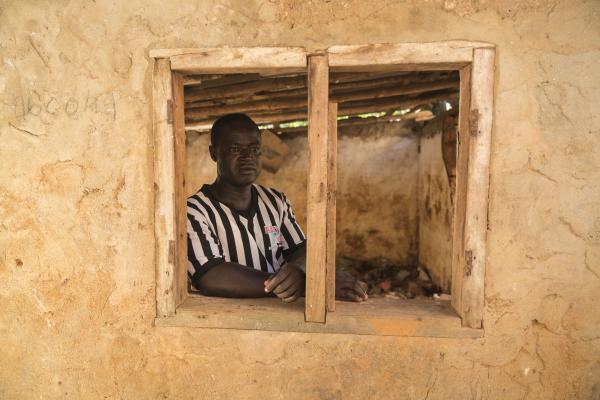Primary actor Alpha Kamara looks out of the window of his house in Kaningo community, Freetown