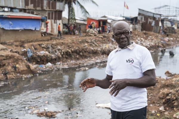 Saidu Turay stood in front of a river in Kroo Bay slum.