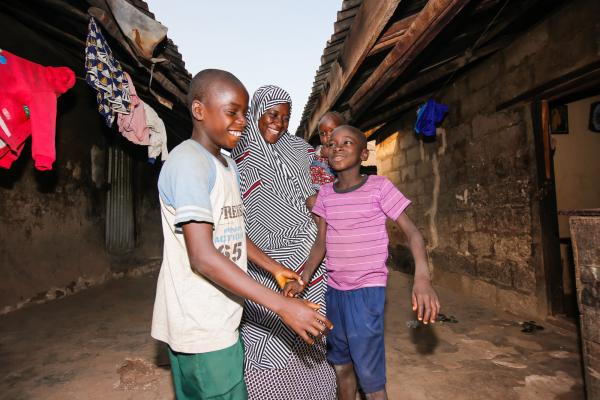 Fatima playing with her children by her home in Niger State, Nigeria.