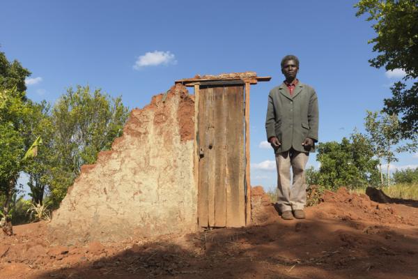 Community leader, Jemusse Jose Chibacha stands in front of a destroyed house in Mudjacure village, Mozambique, after Cyclone Idai.