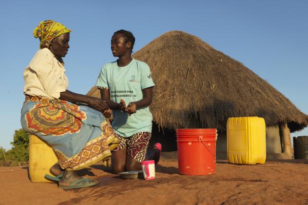 Community volunteer Rosaria teaches Gloria, 65, how to wash hands with ash, soap and water in a cholera prevention campaign after cyclone Idai.