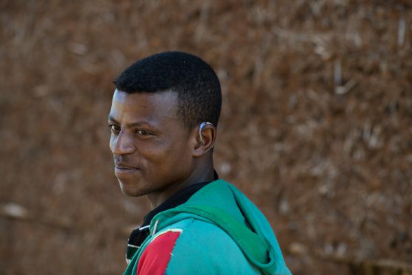 Molla, 17, was provided a hearing aid by VSO. boy with a hearing aid