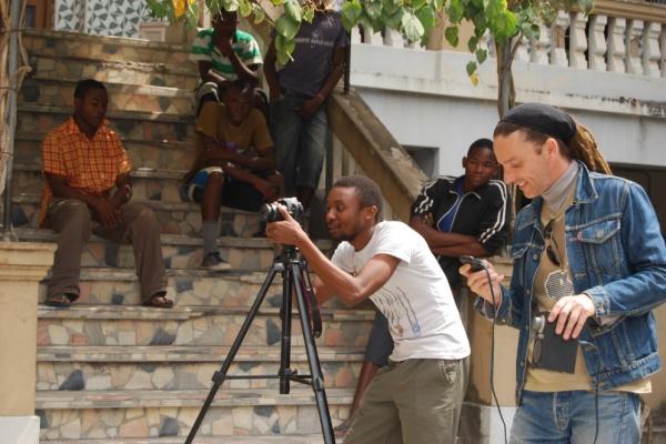 Two men stood outside with a camera, filming