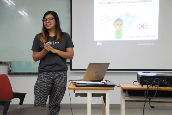 Girl standing in front of a classroom, presenting 